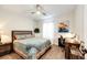Bright bedroom with a patterned comforter, a ceiling fan, and a desk with a chair at 4820 S County Road 137, Bennett, CO 80102