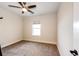 A simple bedroom with carpet flooring, one window, and a ceiling fan light fixture at 4820 S County Road 137, Bennett, CO 80102