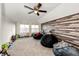 Bonus room with wood accent wall, carpet, beanbag chairs, and natural light from the windows at 4820 S County Road 137, Bennett, CO 80102