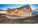 Charming two-story home boasts a three-car garage, neutral siding, and a neatly graveled yard at 4820 S County Road 137, Bennett, CO 80102