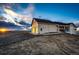 Exterior view of a tan two-story home with a two car garage, covered porch, and white fencing at 4820 S County Road 137, Bennett, CO 80102