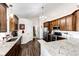 Bright kitchen with stainless steel appliances, granite countertops, wooden cabinets, and an island with bar seating at 4820 S County Road 137, Bennett, CO 80102