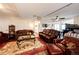 Spacious living room featuring hardwood floors, a ceiling fan, a leather couch, and a rug at 4820 S County Road 137, Bennett, CO 80102