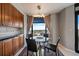 Cozy dining area with a modern light fixture, glass table, and large window offering city views at 8100 E Union Ave # 1603, Denver, CO 80237