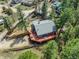 Aerial view of the home boasting a large red deck, scenic views, set amongst lush greenery and mature trees at 3439 Burnham Dr, Kittredge, CO 80457