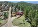 Scenic aerial view featuring a charming home, a large wooden fence and expansive natural surroundings at 3439 Burnham Dr, Kittredge, CO 80457