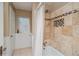 Bathroom showcases stone tiled shower, window, and white wainscotting at 3439 Burnham Dr, Kittredge, CO 80457