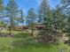 Stunning exterior view of home surrounded by lush greenery, featuring a large deck perfect for entertaining and relaxation at 3439 Burnham Dr, Kittredge, CO 80457
