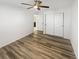 Neutral bedroom with plank flooring and a ceiling fan, featuring double closets and a partial bathroom view at 228 N Edge Cliff St, Castle Rock, CO 80104