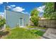 The backyard has a charming blue shed, well-kept lawn, and a stepping stone pathway for easy access at 269 Delaware St, Denver, CO 80223