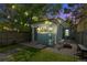 Backyard at night with a fire pit, small building and tree with string lights at 269 Delaware St, Denver, CO 80223