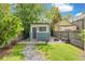 Landscaped backyard with a small building, fire pit, and lush greenery at 269 Delaware St, Denver, CO 80223