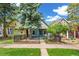 Charming home featuring blue paint, mature trees, black wrought iron fence, and a well-manicured lawn at 269 Delaware St, Denver, CO 80223