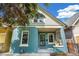 A well maintained blue home with green trim shows off its inviting porch and manicured front yard at 269 Delaware St, Denver, CO 80223