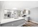 Bright kitchen features stainless steel appliances, light grey cabinets, island with seating at 269 Delaware St, Denver, CO 80223