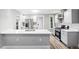 Bright kitchen features stainless steel appliances, light grey cabinets, island with seating at 269 Delaware St, Denver, CO 80223