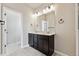 Well-lit bathroom with double vanity, dark wood cabinets, and tile flooring at 6834 Merseyside Ln, Castle Pines, CO 80108