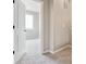 Hallway leading to a bedroom with neutral carpet, light gray walls, and an open white interior door at 6834 Merseyside Ln, Castle Pines, CO 80108
