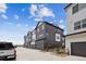 Modern townhome complex featuring stylish architecture and individual garages at 6834 Merseyside Ln, Castle Pines, CO 80108