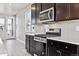 Modern kitchen features stainless steel appliances, dark cabinetry, and light countertops at 6834 Merseyside Ln, Castle Pines, CO 80108