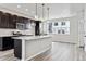 Stylish kitchen with an island, stainless steel appliances, dark cabinetry, and tile backsplash at 6834 Merseyside Ln, Castle Pines, CO 80108