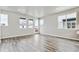 Bright, open living room with hardwood floors and ample natural light from large windows at 6834 Merseyside Ln, Castle Pines, CO 80108