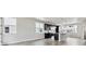 Open-concept living space with wood floors flowing into a modern kitchen with island at 6834 Merseyside Ln, Castle Pines, CO 80108