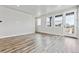Spacious living room featuring modern wood floors, large windows, and neutral wall color at 6834 Merseyside Ln, Castle Pines, CO 80108