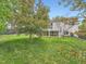 Spacious backyard featuring lush green grass, mature trees, and a patio with a second story deck at 12991 E Idaho Dr, Aurora, CO 80012