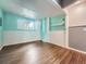 Finished basement showcasing bright blue accent wall and hardwood floors and a window at 12991 E Idaho Dr, Aurora, CO 80012