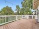 Enjoy outdoor living on this wood deck with white railing and string lights against a backdrop of trees at 12991 E Idaho Dr, Aurora, CO 80012