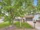 Charming home with mature trees, a well-kept lawn, and gray garage door at 12991 E Idaho Dr, Aurora, CO 80012