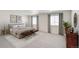 Bright main bedroom featuring large windows, plush carpeting, and a neutral color palette at 17847 Dandy Brush Dr, Parker, CO 80134