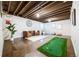 Finished basement with exposed ceiling, polished concrete floor, decorative putting green, and comfortable lounge area at 1940 W 101St Ct, Thornton, CO 80260