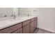 Double vanity bathroom with light wood cabinets and a quartz countertop at 1242 S Algonquian, Aurora, CO 80018