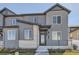 Two-story townhome with gray siding, brick accents, and a modern front entrance at 1242 S Algonquian, Aurora, CO 80018