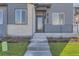 Modern front entrance with gray siding, brick accents, and concrete steps at 1242 S Algonquian, Aurora, CO 80018