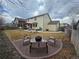 Spacious backyard featuring a stone fire pit area, a patio with a pergola, and a well-manicured lawn at 13018 Niagara Way, Thornton, CO 80602