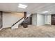 Finished basement featuring carpet, stairs, wood beam, and stylish ceiling tiles at 13018 Niagara Way, Thornton, CO 80602