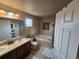 Bathroom features double sinks, bathtub, shower with glass door, neutral paint, and lots of natural light at 13018 Niagara Way, Thornton, CO 80602