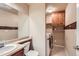 Functional bathroom and laundry space, with a sink vanity, toilet, and a washer and dryer at 13018 Niagara Way, Thornton, CO 80602