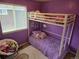 A purple bedroom featuring a bunk bed with a chair covered with stuffed animals at 13018 Niagara Way, Thornton, CO 80602