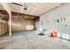 Spacious garage featuring concrete floors, exposed ceiling and partial wall coverings, and a garage door at 13018 Niagara Way, Thornton, CO 80602