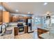 Modern kitchen featuring stainless steel appliances, wood cabinets, and granite countertops at 13018 Niagara Way, Thornton, CO 80602