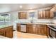 Bright kitchen showcasing granite countertops, wooden cabinetry, and stainless steel appliances at 13018 Niagara Way, Thornton, CO 80602