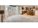 Bright kitchen area with stainless appliances, wooden cabinets, and ample sunlight from bay windows at 13018 Niagara Way, Thornton, CO 80602