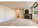 Spacious living room with stone fireplace, neutral carpet, and a large sunlit window at 13018 Niagara Way, Thornton, CO 80602