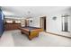 Basement with a pool table, exposed brick, and updated lighting at 415 Lamar St, Lakewood, CO 80226