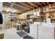 Unfinished basement area with washer, dryer, and ample storage shelving at 415 Lamar St, Lakewood, CO 80226