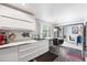 Contemporary kitchen with sleek white cabinets, breakfast bar, and open access to the dining area at 415 Lamar St, Lakewood, CO 80226
